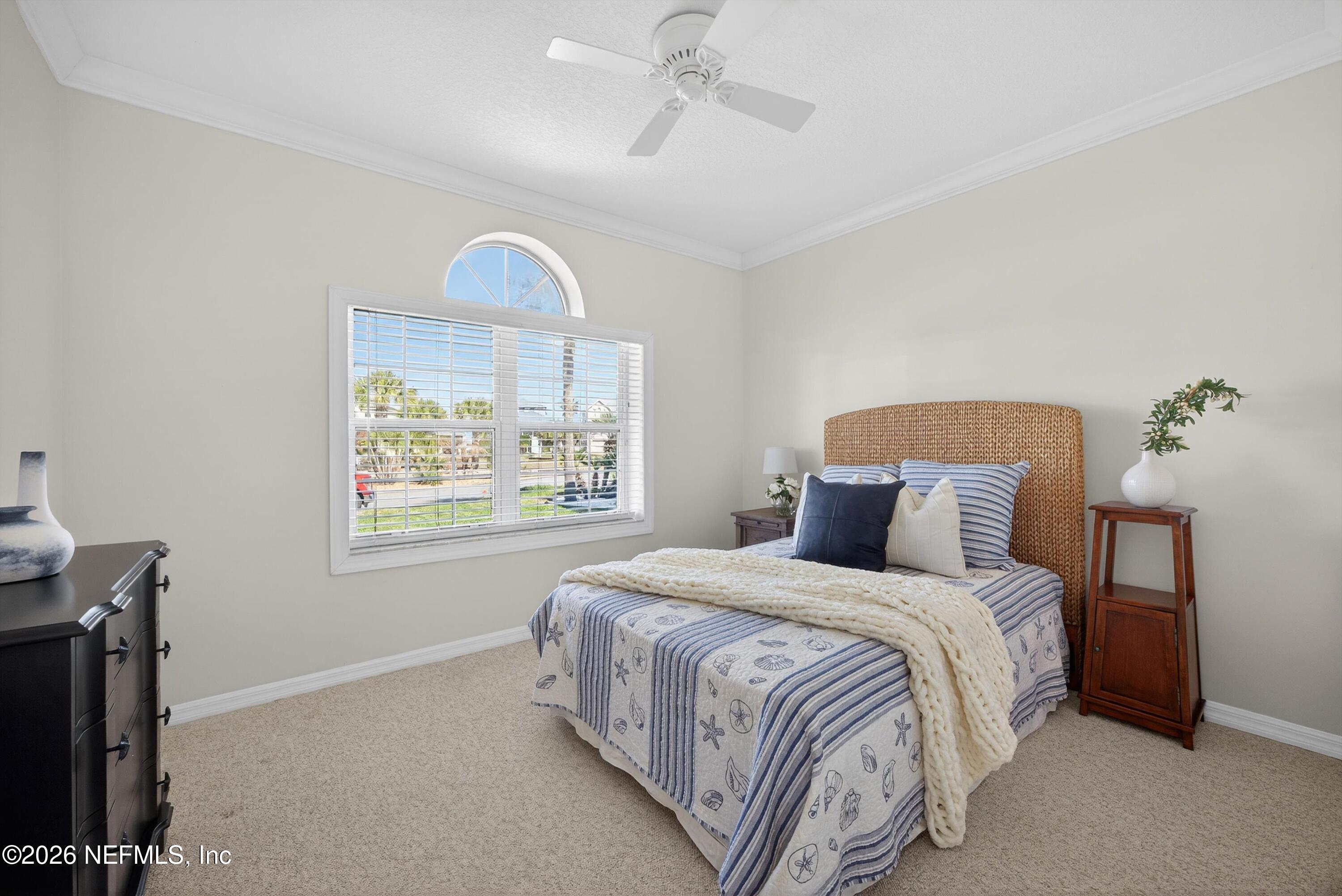 9179 June Lane St. Augustine, FL 32080 - Photo 21 of 56 a bedroom with a bed and a chandelier