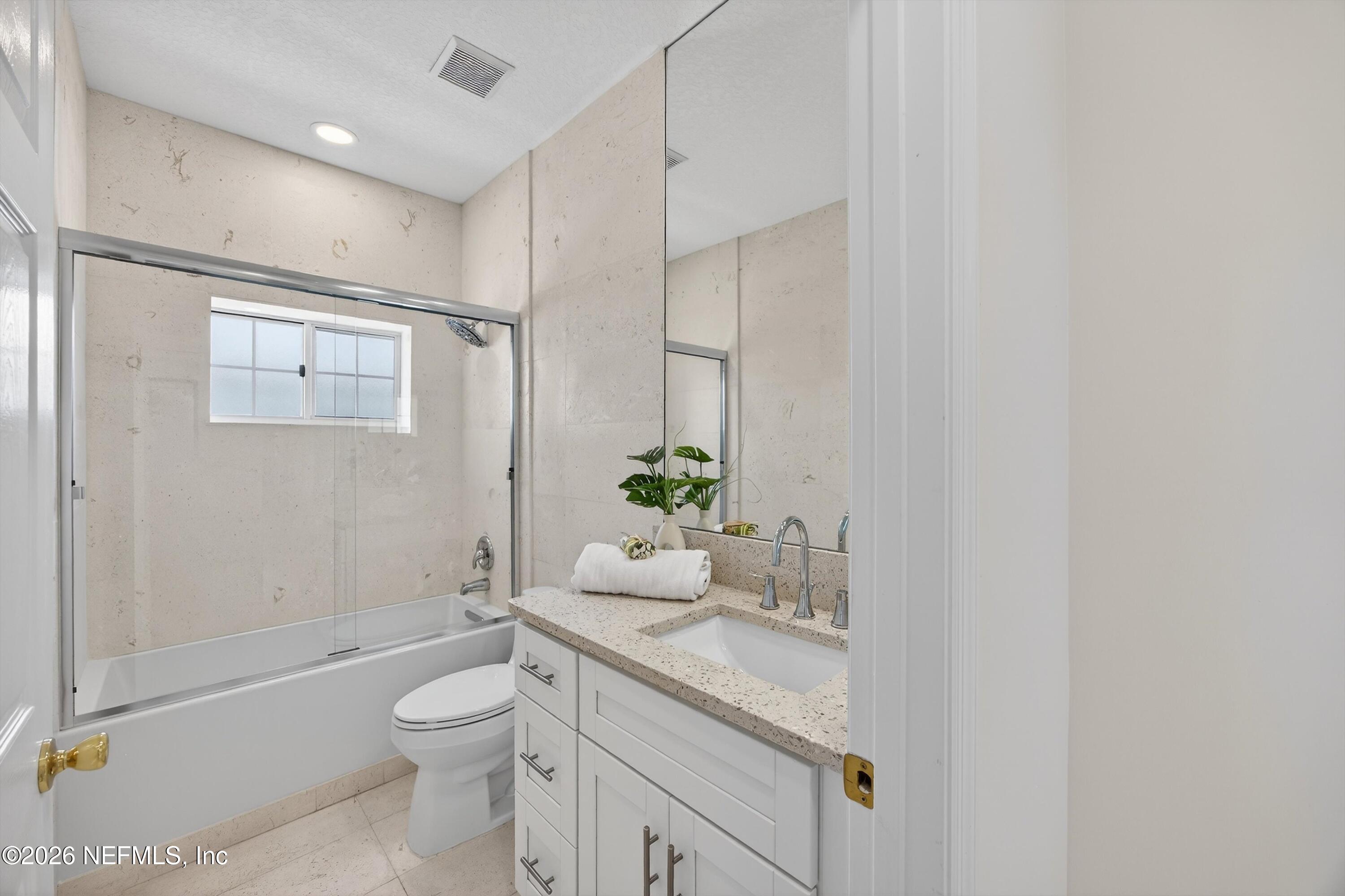 9179 June Lane St. Augustine, FL 32080 - Photo 22 of 56 a bathroom with a granite countertop sink a toilet and shower