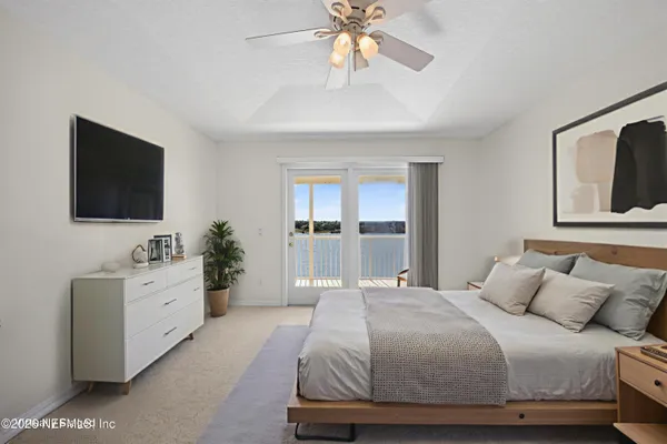an empty room with chandelier fan and windows