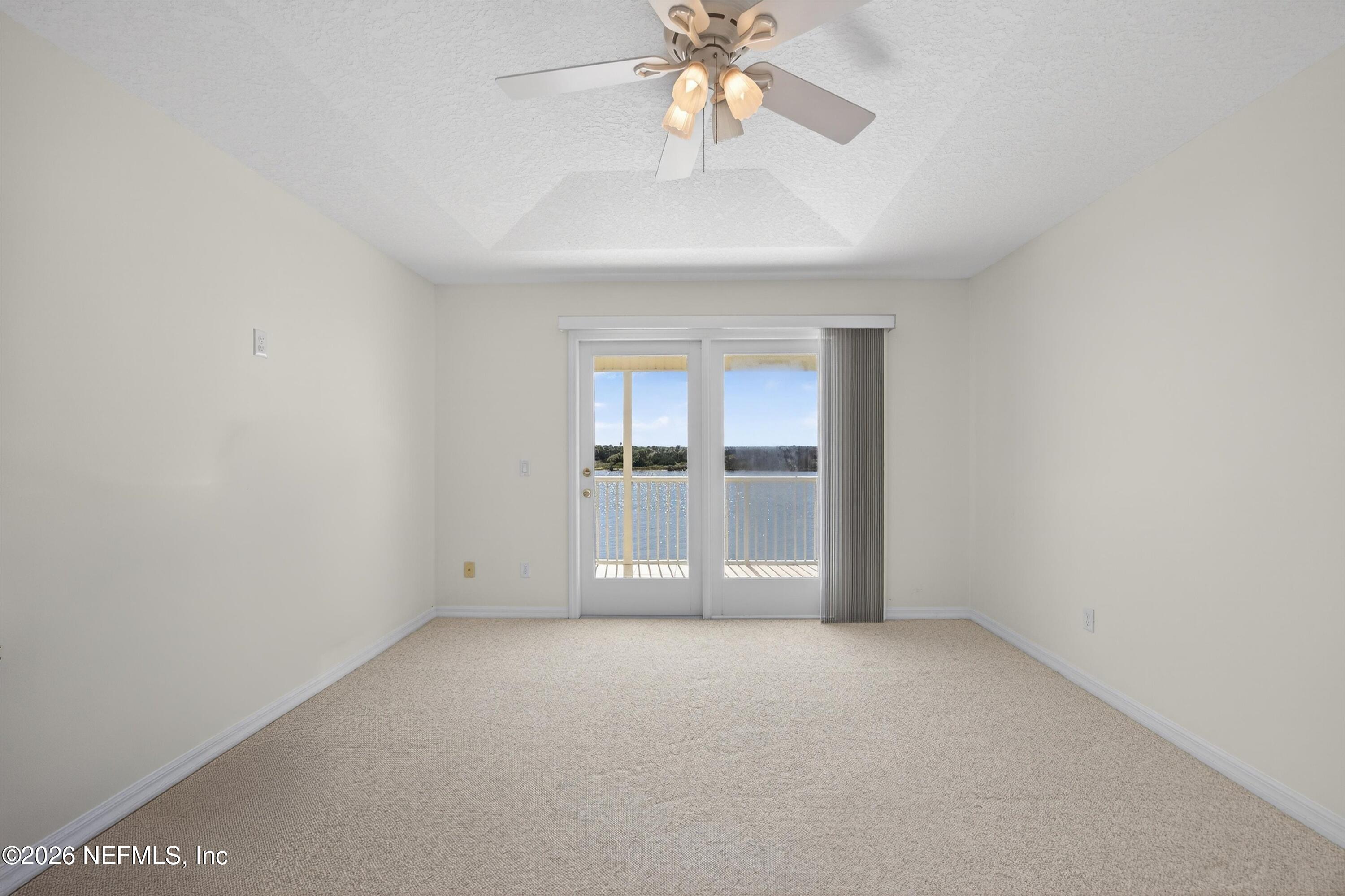 9179 June Lane St. Augustine, FL 32080 - Photo 25 of 56 an empty room with chandelier fan and windows