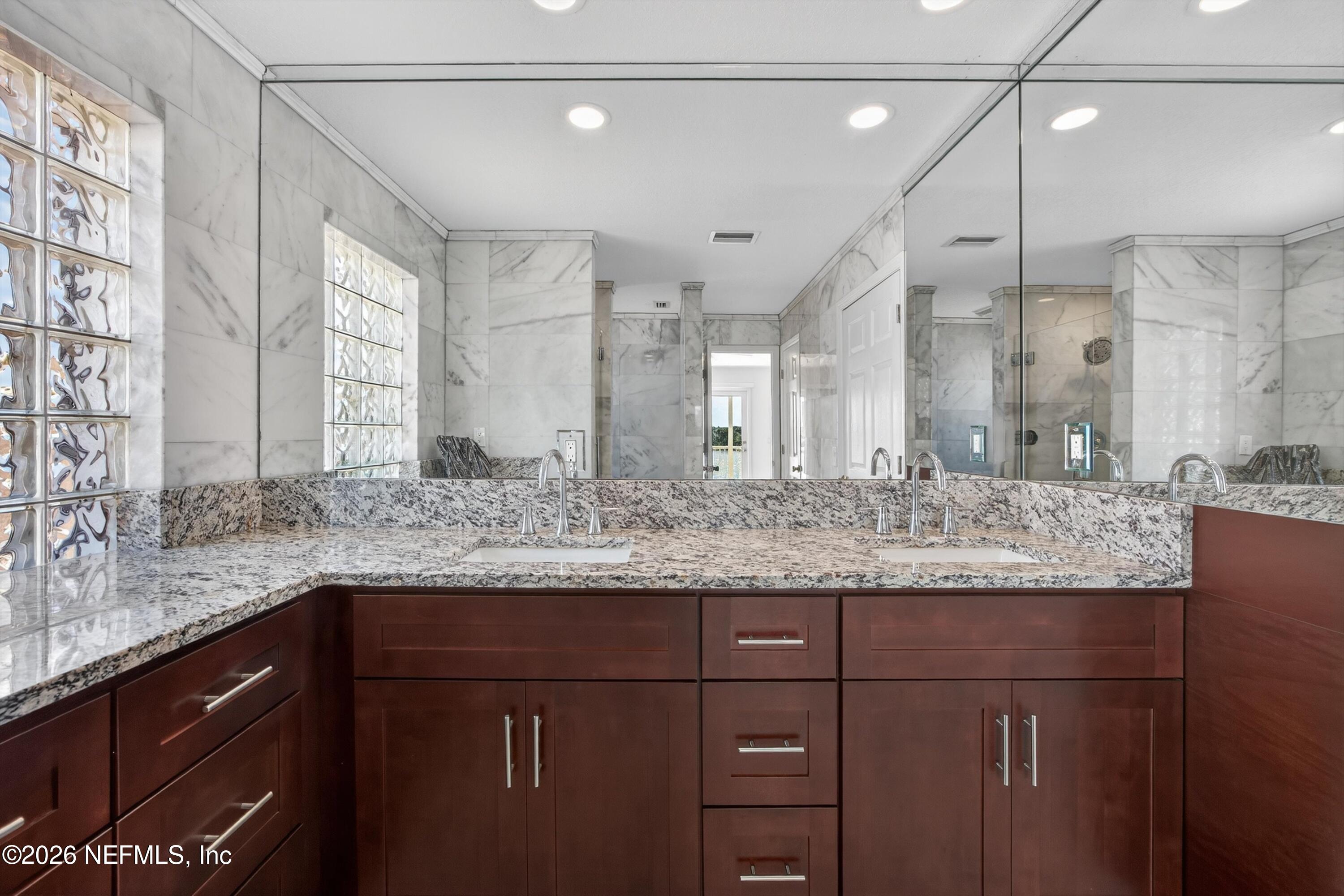 9179 June Lane St. Augustine, FL 32080 - Photo 27 of 56 a bathroom with a granite countertop sink a mirror and shower