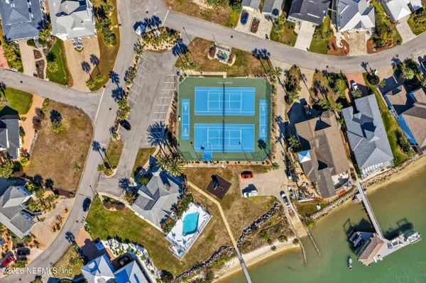an aerial view of ocean and residential houses with outdoor space