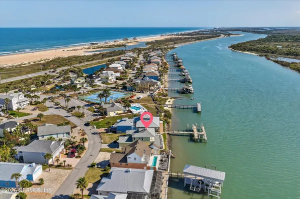 an aerial view of residential houses with outdoor space and lake view