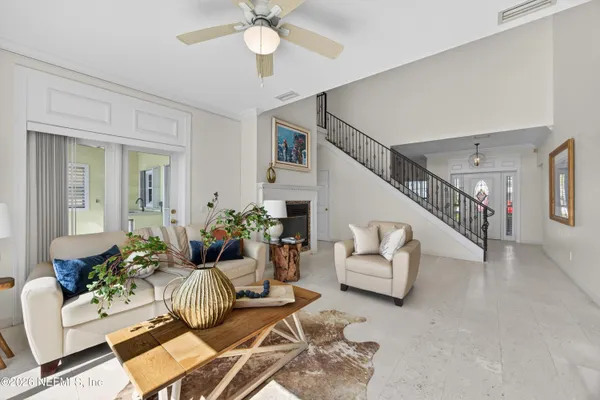 a living room with furniture a fireplace and a floor to ceiling window