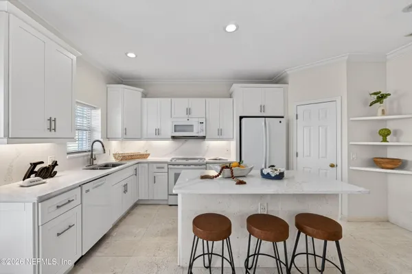 a kitchen with white cabinets and stainless steel appliances