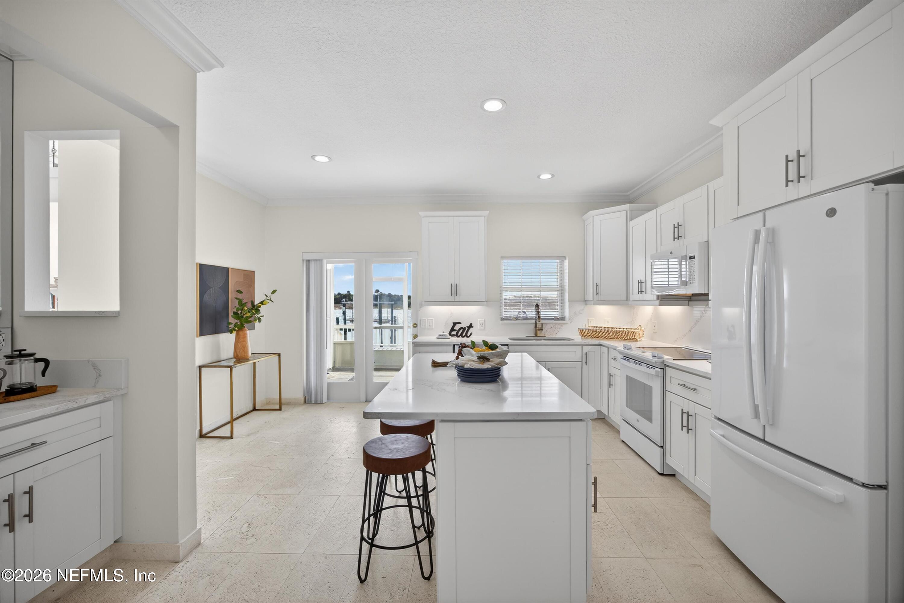 9179 June Lane St. Augustine, FL 32080 - Photo 10 of 56 a kitchen with white cabinets and stainless steel appliances