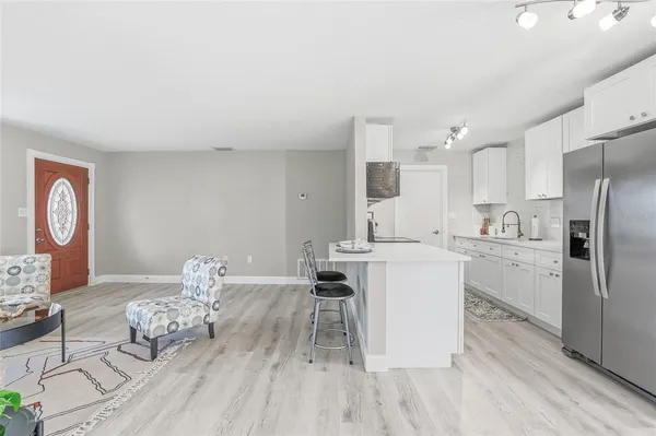 a kitchen with kitchen island stainless steel appliances a stove refrigerator sink and cabinets