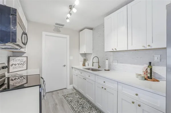 a kitchen with stainless steel appliances granite countertop a sink and a white cabinets