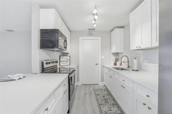 a kitchen with stainless steel appliances granite countertop a sink and cabinets