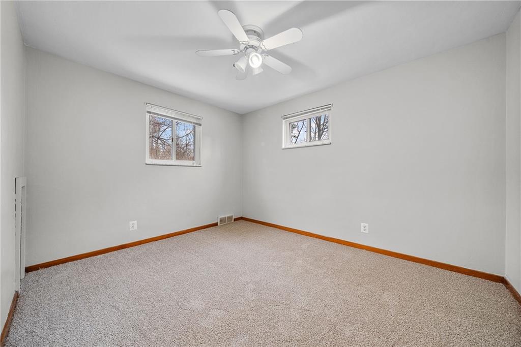 1041 Ardmore Manor Drive Pittsburgh, PA 15221 - Photo 18 of 38 an empty room with a chandelier fan and windows