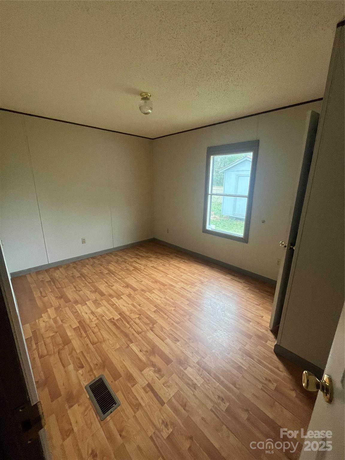 124 Saylor Lane Stony Point, NC 28678 - Photo 9 of 11 an empty room with wooden floor and windows