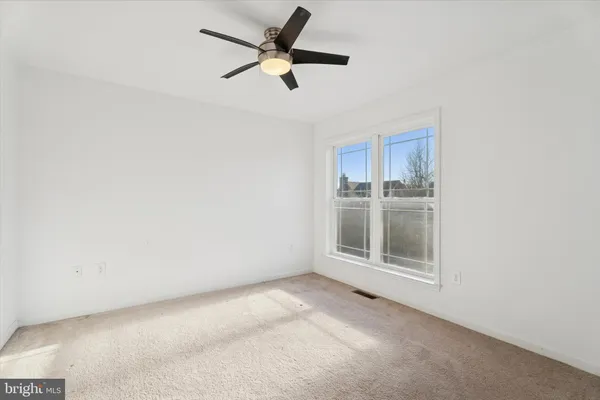 an empty room with a empty space and a ceiling fan