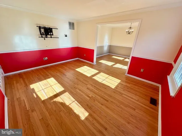 a living room with a bed and a dresser with wooden floor