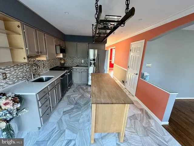 a view of a kitchen with wooden floor and electronic appliances