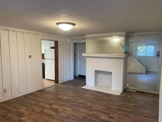 a view of a livingroom with a fireplace wooden floor and window