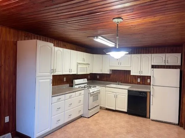 a kitchen with white cabinets and white appliances
