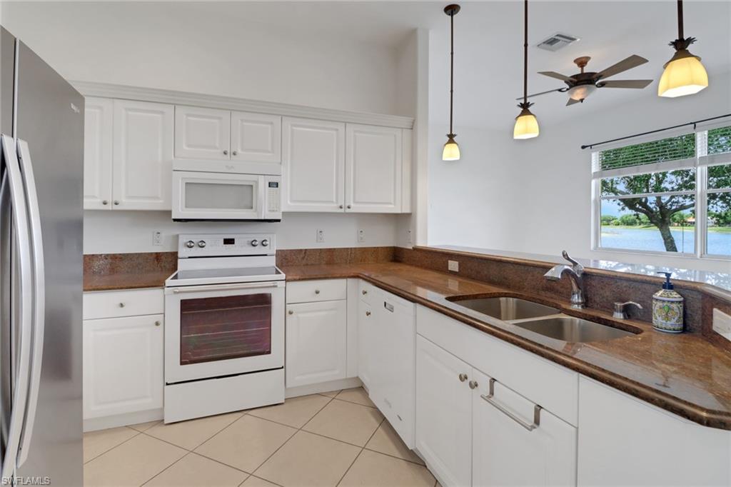 3283 Potomac Court Naples, FL 34120 - Photo 12 of 29 Kitchen featuring pendant lighting, ceiling fan, a sink, and white appliances