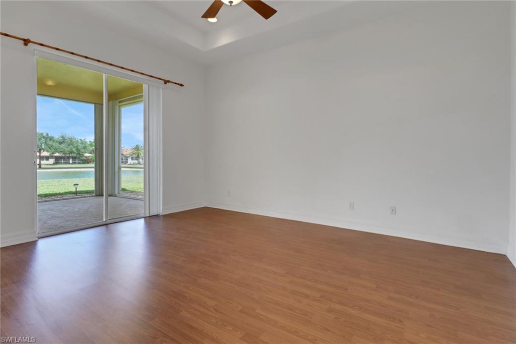 3283 Potomac Court Naples, FL 34120 - Photo 13 of 29 Spare room featuring baseboards, ceiling fan, wood finished floors, and a raised ceiling