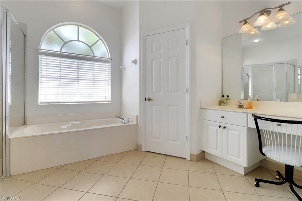 3283 Potomac Court Naples, FL 34120 - Photo 14 of 29 Full bath with tile patterned floors, vanity, a stall shower, and a garden tub