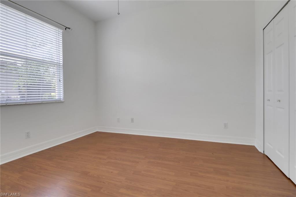 3283 Potomac Court Naples, FL 34120 - Photo 16 of 29 Unfurnished bedroom featuring baseboards, wood finished floors, and a closet