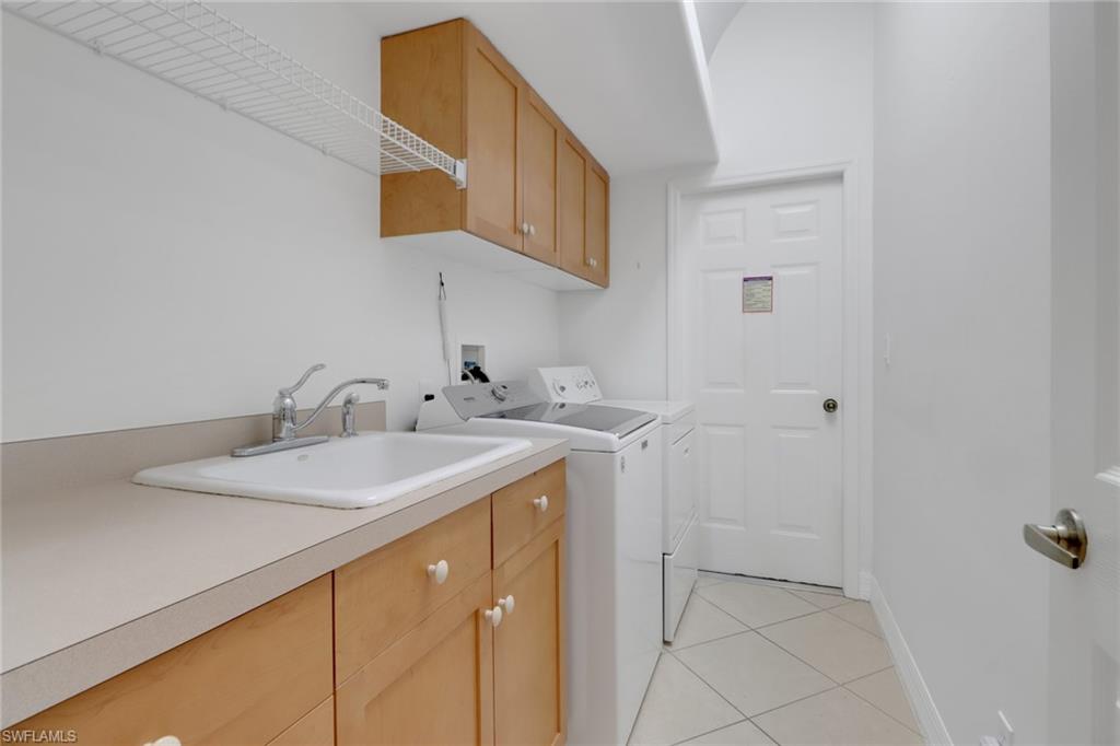 3283 Potomac Court Naples, FL 34120 - Photo 19 of 29 Clothes washing area with light tile patterned flooring, washer and clothes dryer, a sink, baseboards, and cabinet space