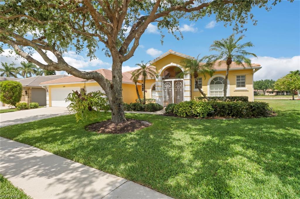 3283 Potomac Court Naples, FL 34120 - Photo 2 of 29 View of front of house with a tile roof, stucco siding, an attached garage, driveway, and a front lawn