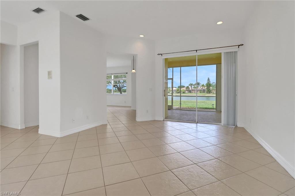 3283 Potomac Court Naples, FL 34120 - Photo 5 of 29 Empty room with a water view, visible vents, baseboards, recessed lighting, and light tile patterned floors