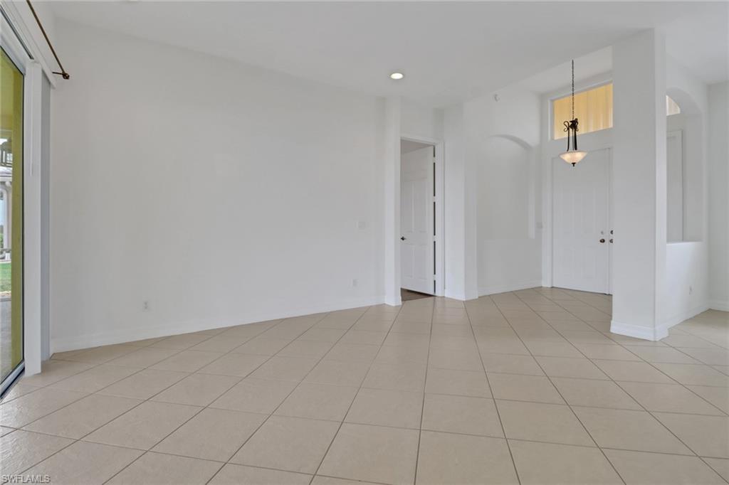 3283 Potomac Court Naples, FL 34120 - Photo 6 of 29 Empty room featuring light tile patterned floors, baseboards, and a wealth of natural light