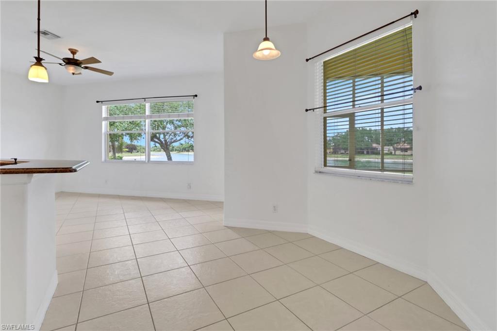 3283 Potomac Court Naples, FL 34120 - Photo 7 of 29 Empty room featuring light tile patterned flooring, baseboards, visible vents, and a ceiling fan