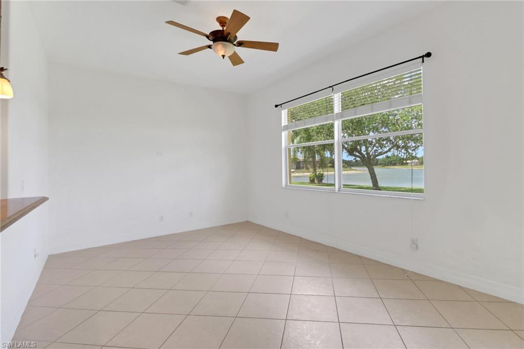 3283 Potomac Court Naples, FL 34120 - Photo 8 of 29 Empty room with a ceiling fan, light tile patterned floors, a water view, and baseboards