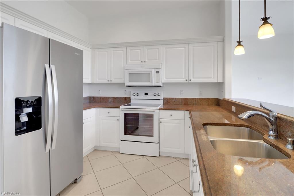 3283 Potomac Court Naples, FL 34120 - Photo 10 of 29 Kitchen with hanging light fixtures, white cabinets, a sink, and white appliances