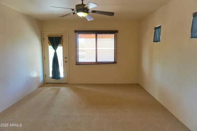 an empty room with windows and fan
