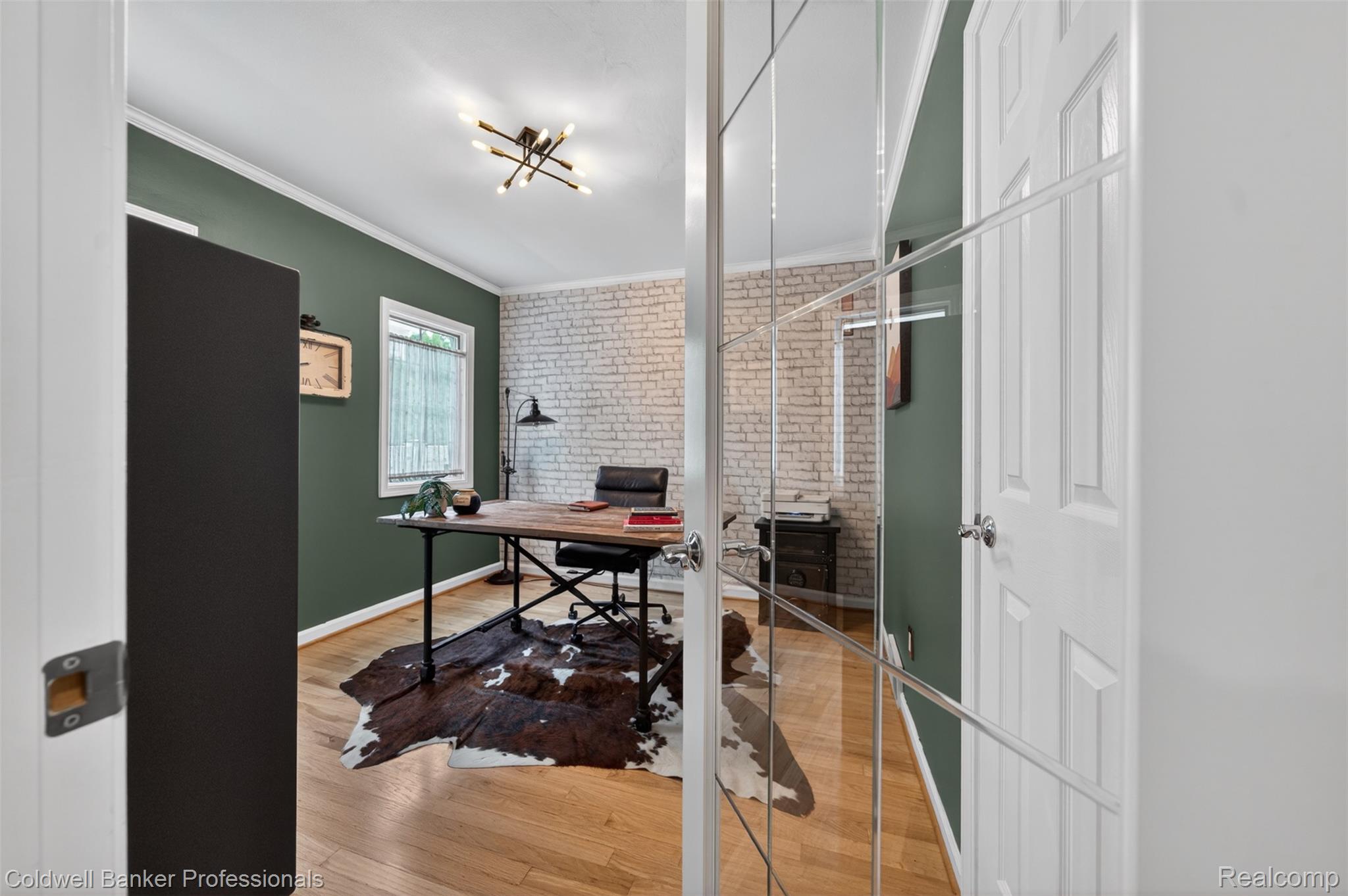2666 Windemere Road Birmingham, MI 48009 - Photo 8 of 24 Office space featuring hardwood flooring, a white-painted brick accent wall, and a modern ceiling light fixture