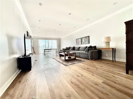 a living room with furniture a bed and a flat screen tv