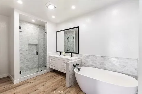 a bathroom with a large tub shower and sink