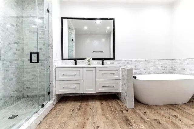 a bathroom with a bathtub sink and mirror
