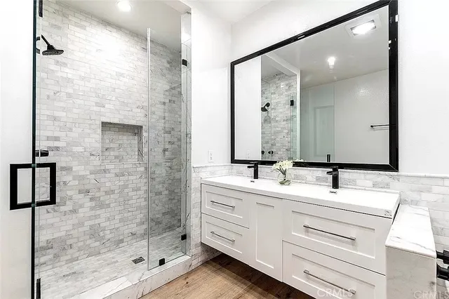 a bathroom with a double vanity sink mirror and shower