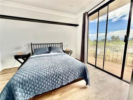 a large bed sitting in a bedroom next to a window