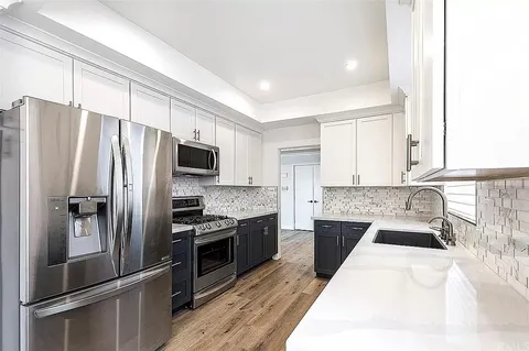 a kitchen with a refrigerator sink and stainless steel appliances