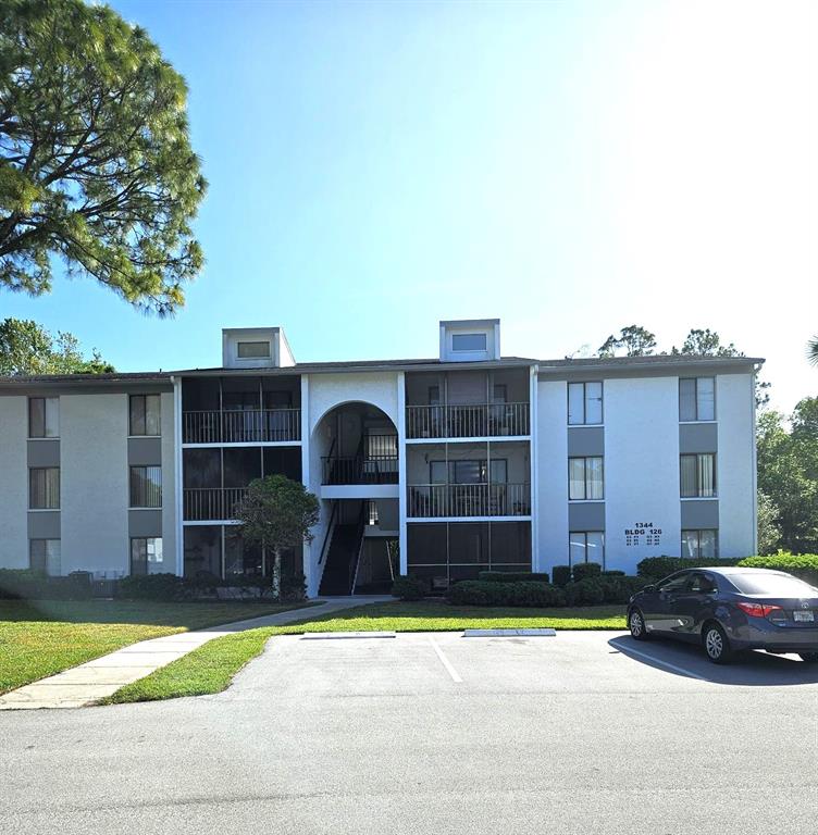 1344 Pine Ridge Circle East, Unit E3 Tarpon Springs, FL 34688 - Photo 1 of 25 a front view of a house with a yard