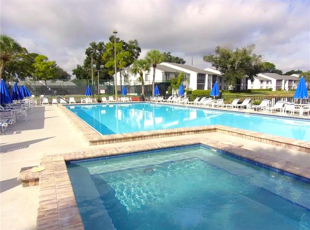 1344 Pine Ridge Circle East, Unit E3 Tarpon Springs, FL 34688 - Photo 13 of 25 a view of swimming pool with outdoor seating and yard