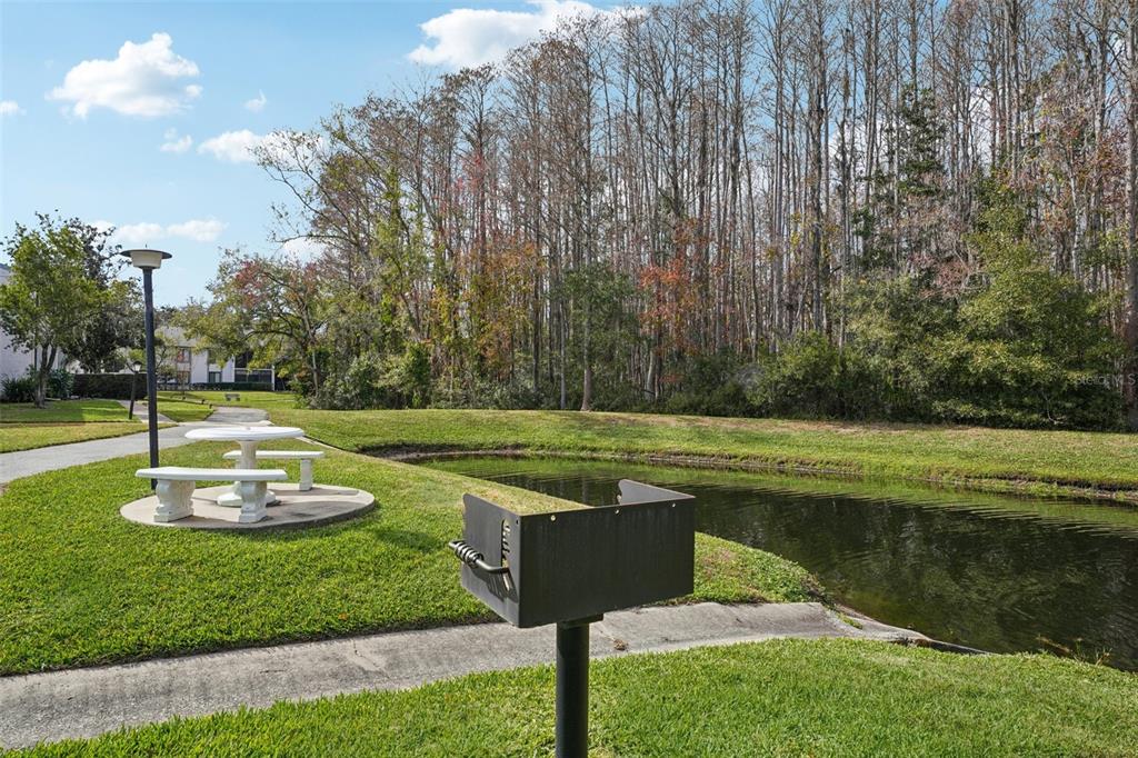 1344 Pine Ridge Circle East, Unit E3 Tarpon Springs, FL 34688 - Photo 17 of 25 a swimming pool with lots of green space and trees in the background