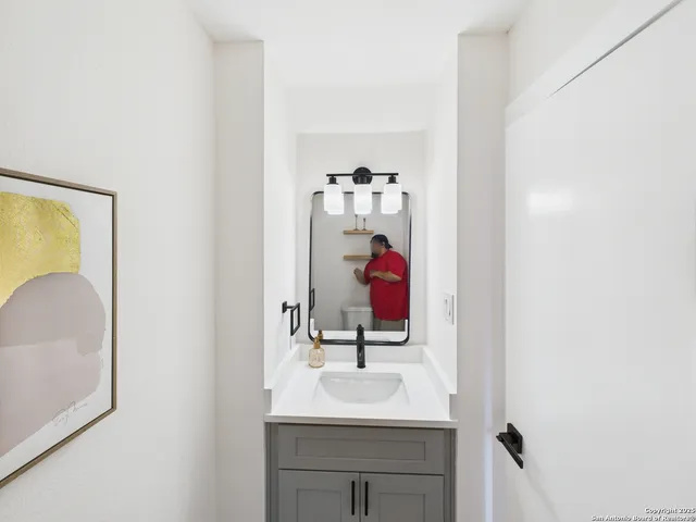 a bathroom with a sink vanity and a mirror