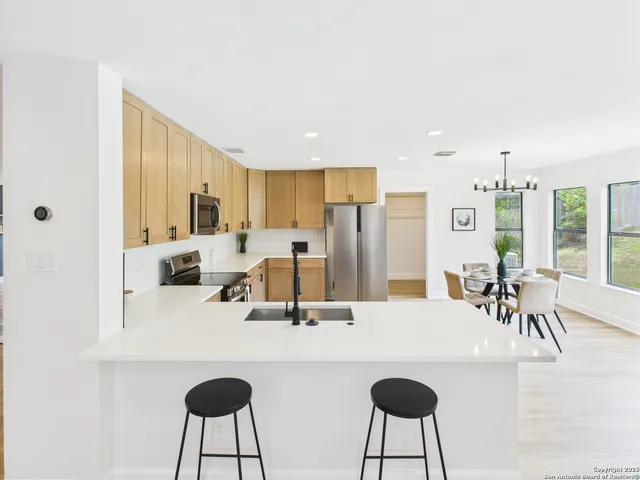 a kitchen with kitchen island a dining table and chairs