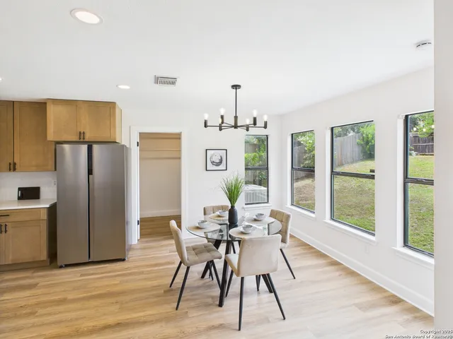 a dining room with furniture a chandelier and wooden floor