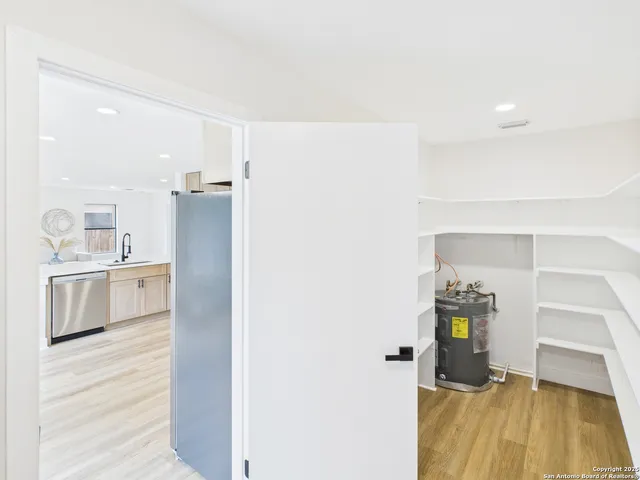 a kitchen with a refrigerator and white cabinets
