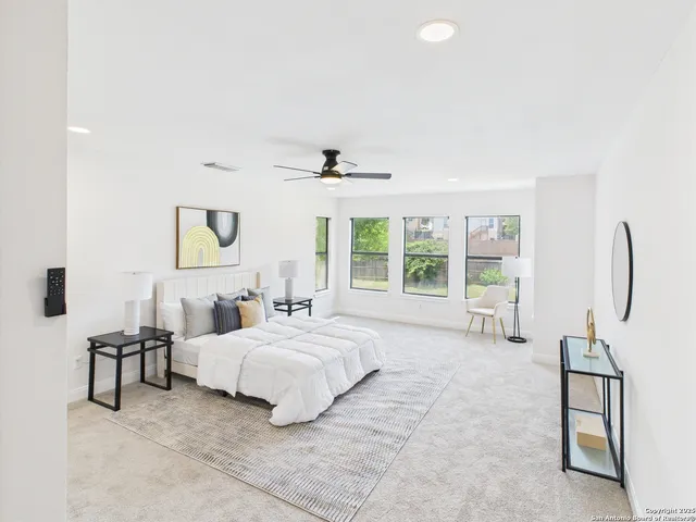 a bedroom with a bed lamps and chairs