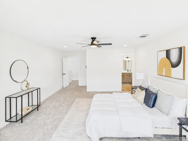 a view of a bedroom with a bed and wooden floor