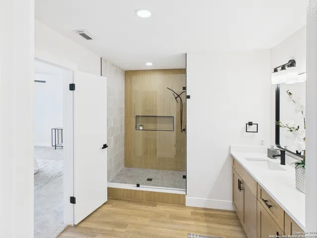 a bathroom with a shower sink and mirror