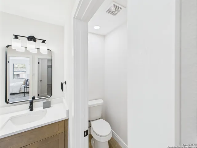 a bathroom with a sink a toilet and a mirror